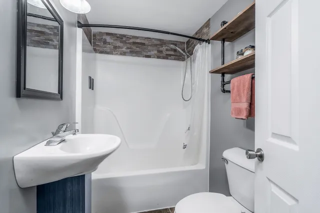 a bathroom with a sink toilet and shower