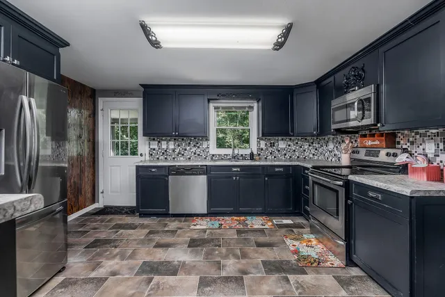 a kitchen with stainless steel appliances granite countertop a sink stove and refrigerator