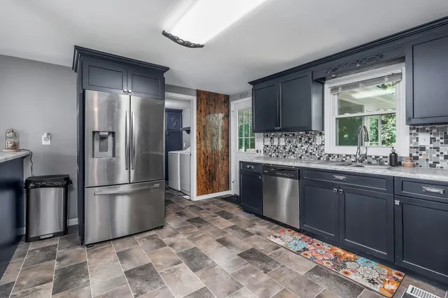 a kitchen with stainless steel appliances granite countertop a refrigerator and a sink