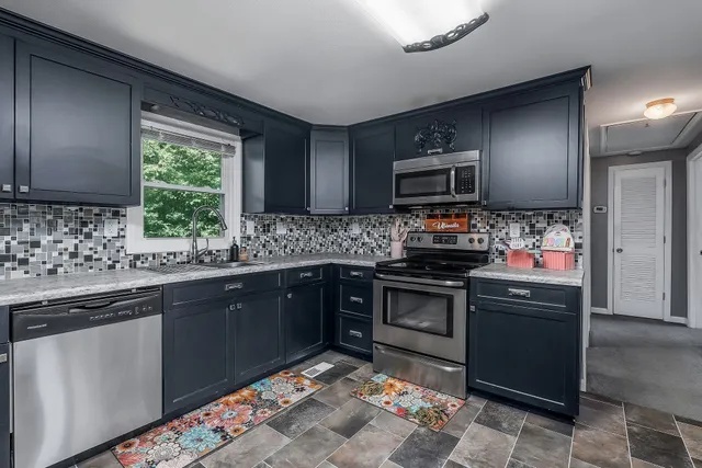 a kitchen with kitchen island granite countertop a stove sink and microwave