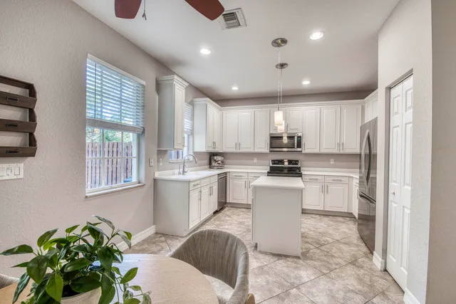 a view of a workspace with furniture and a window