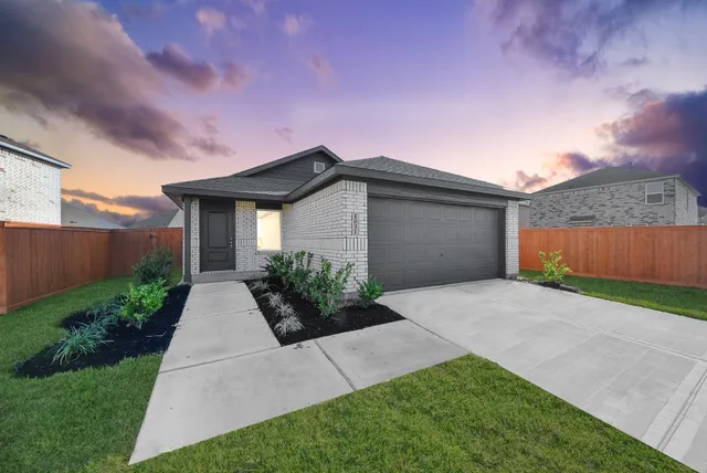 a front view of house with yard and trees around