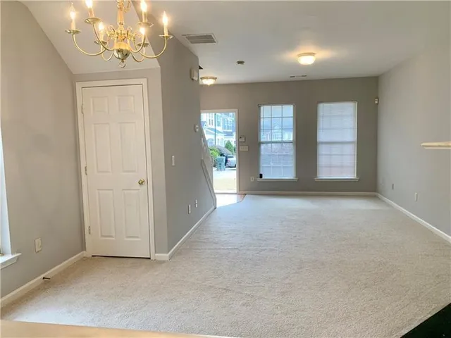 an empty room with chandelier and windows