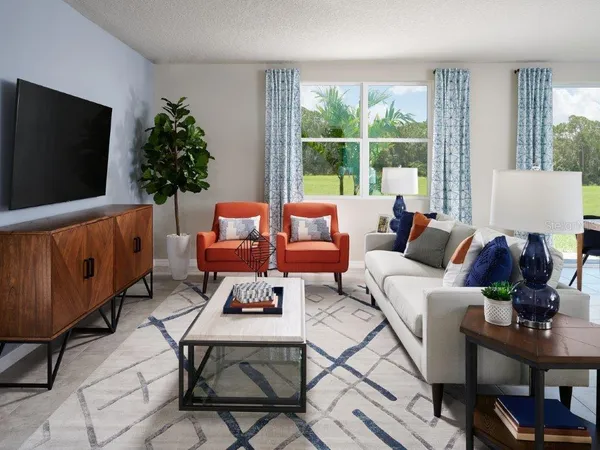 a living room with furniture a flat screen tv and a window