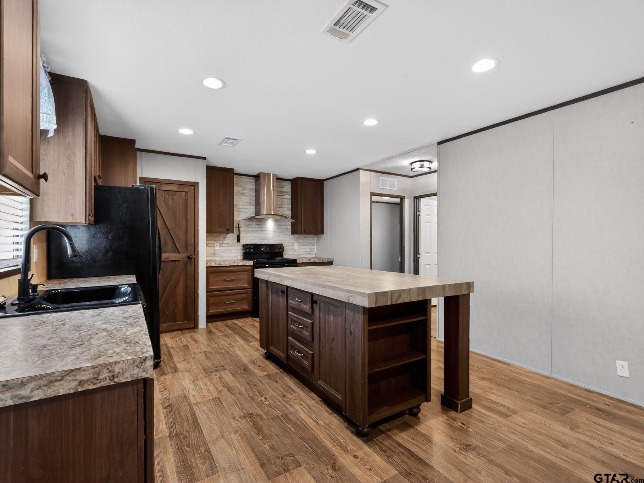 149 Running Bear Quitman, TX 75783 - Photo 11 of 31 a kitchen with stainless steel appliances granite countertop a stove a refrigerator and a sink