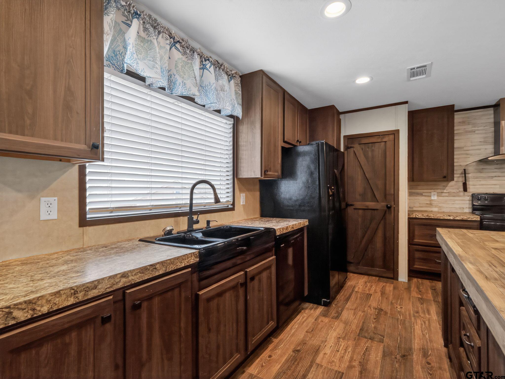 149 Running Bear Quitman, TX 75783 - Photo 12 of 31 a kitchen with stainless steel appliances granite countertop a sink stove and refrigerator