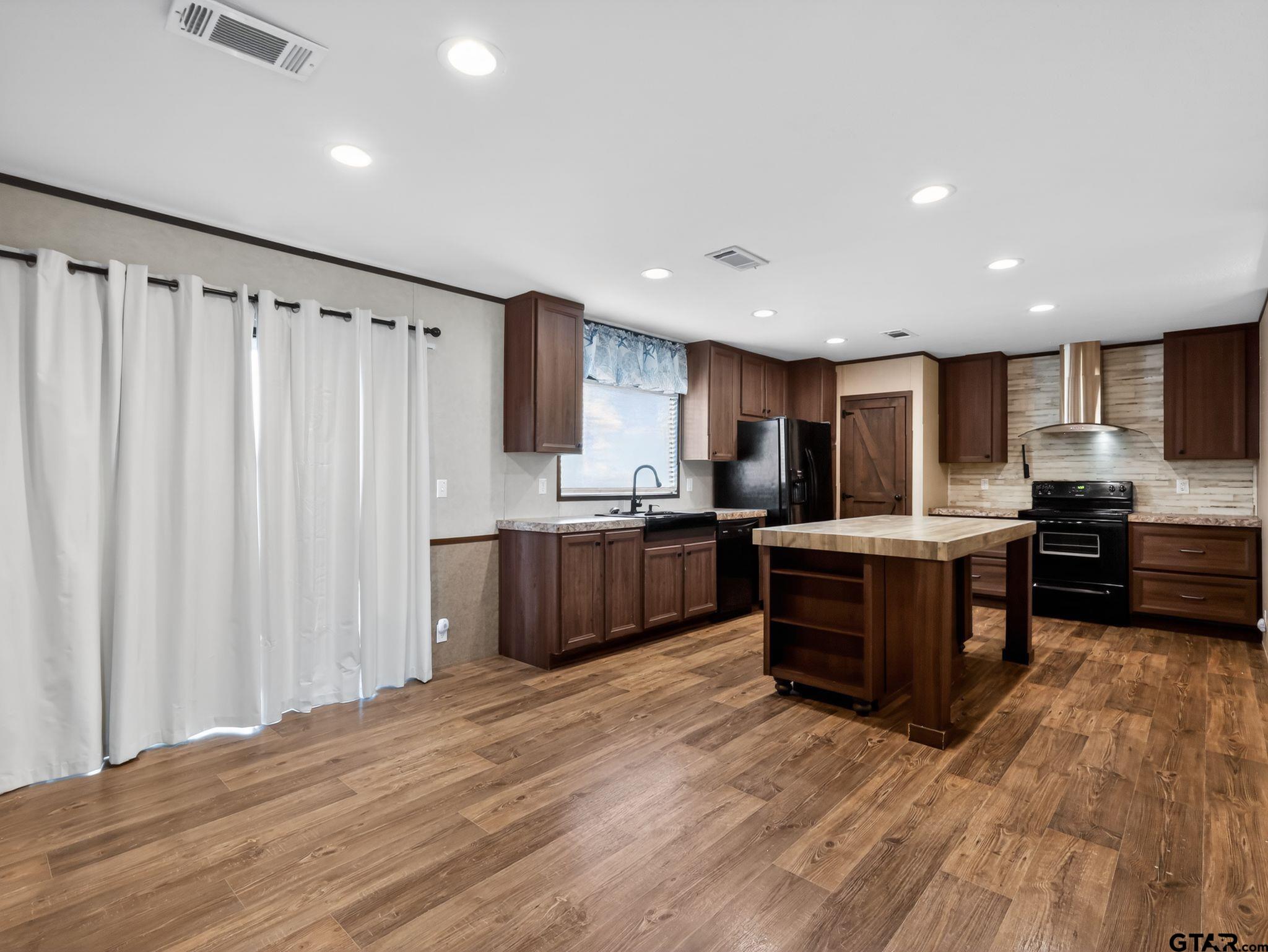 149 Running Bear Quitman, TX 75783 - Photo 15 of 31 a kitchen with stainless steel appliances kitchen island granite countertop a refrigerator and a stove top oven