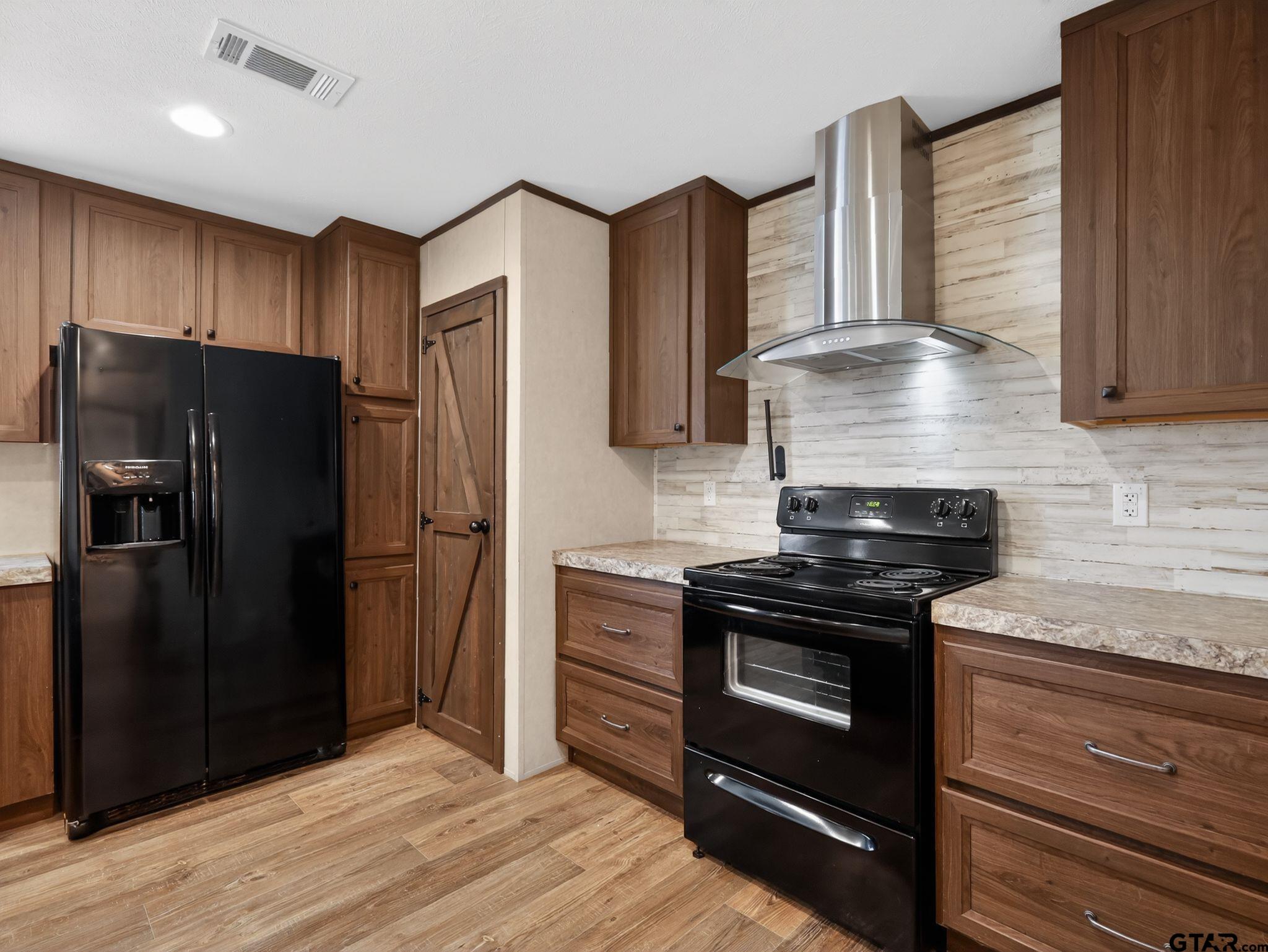149 Running Bear Quitman, TX 75783 - Photo 15 of 41 a kitchen with granite countertop wooden cabinets and stainless steel appliances