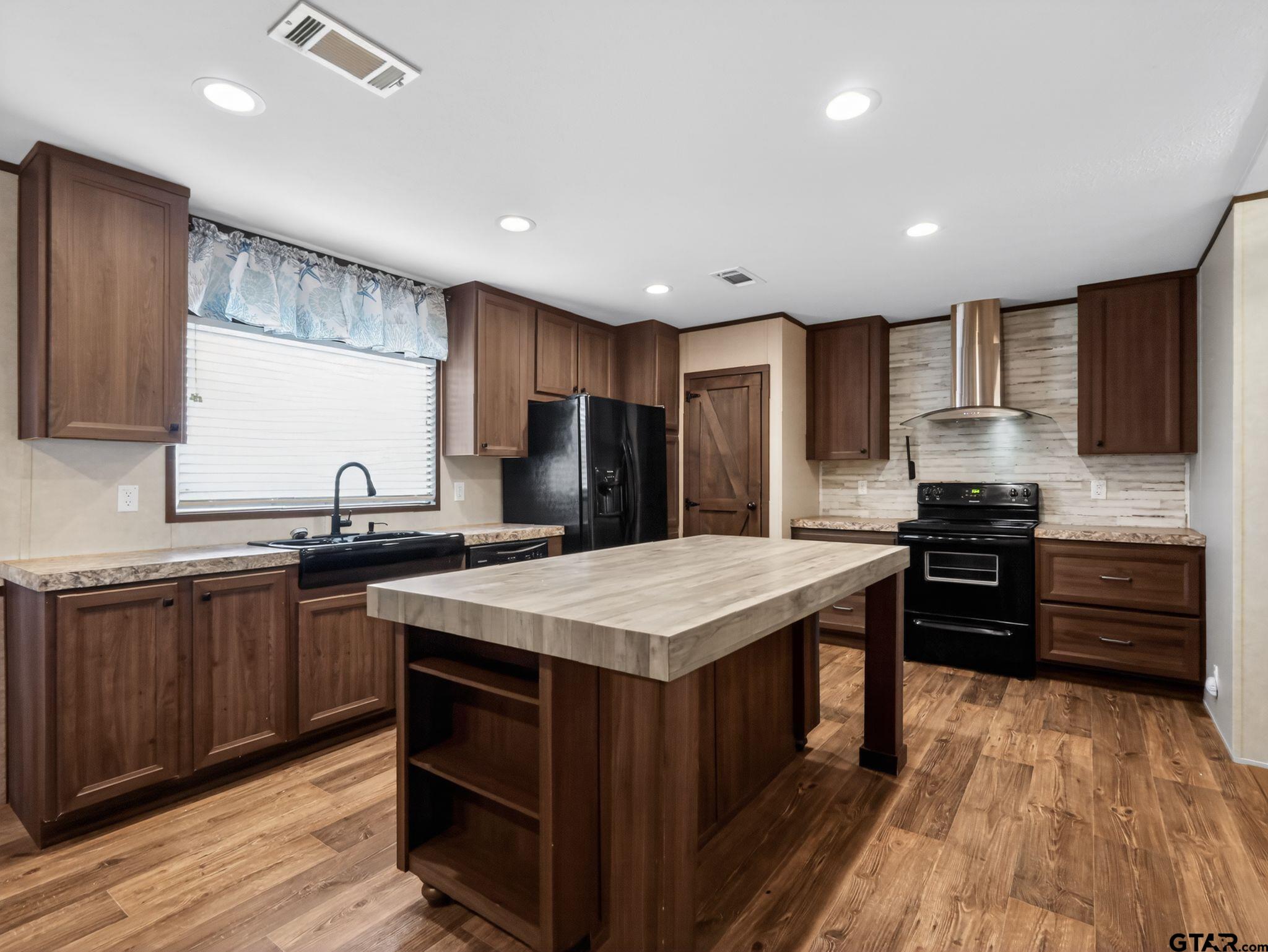 149 Running Bear Quitman, TX 75783 - Photo 9 of 31 a kitchen with a stove a sink a microwave and cabinets