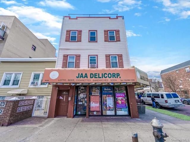 a front view of multi story residential apartment building with retail shops