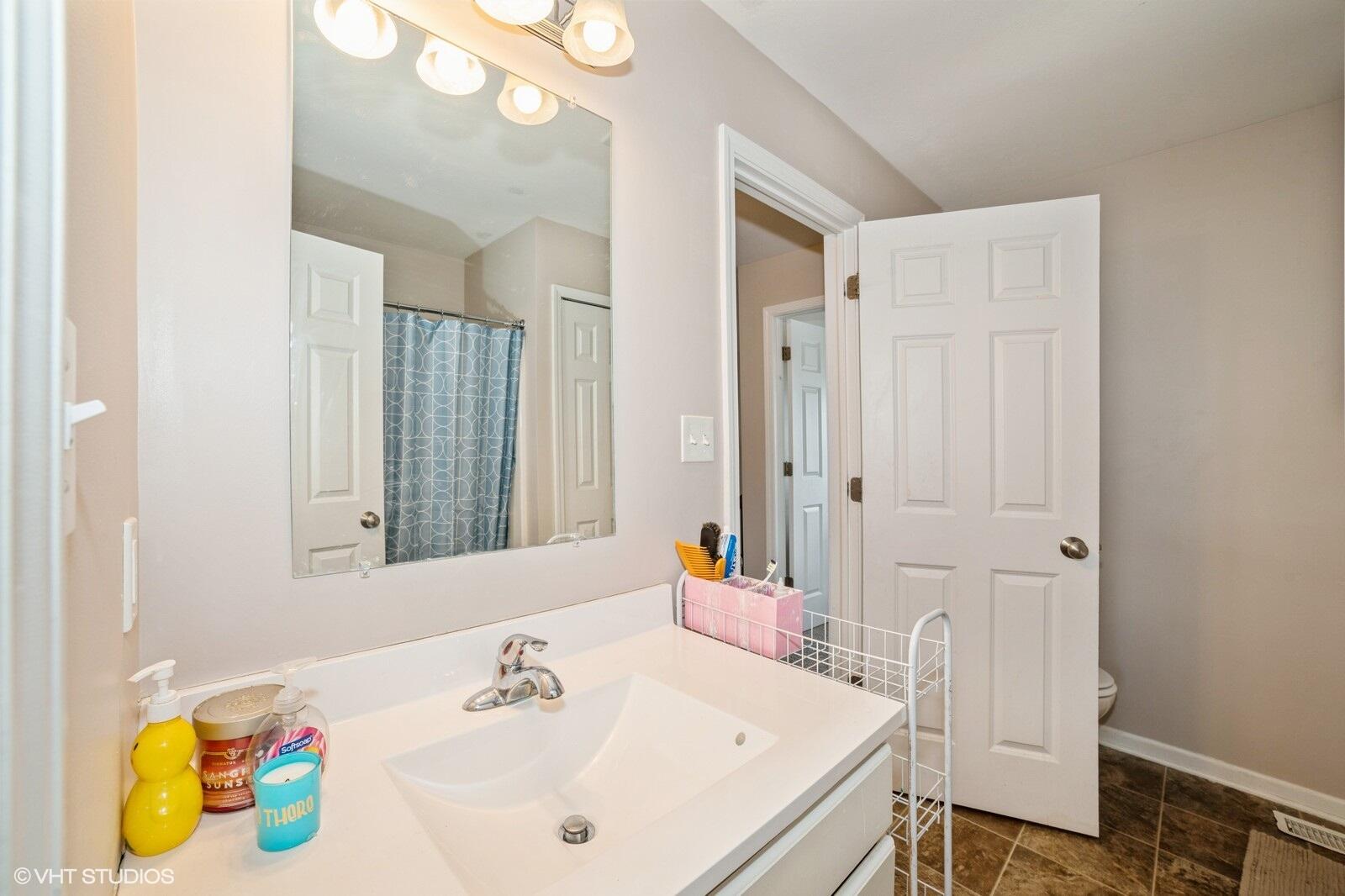 1078 East 114th Avenue Crown Point, IN 46307 - Photo 15 of 20 a bathroom with a sink and a mirror