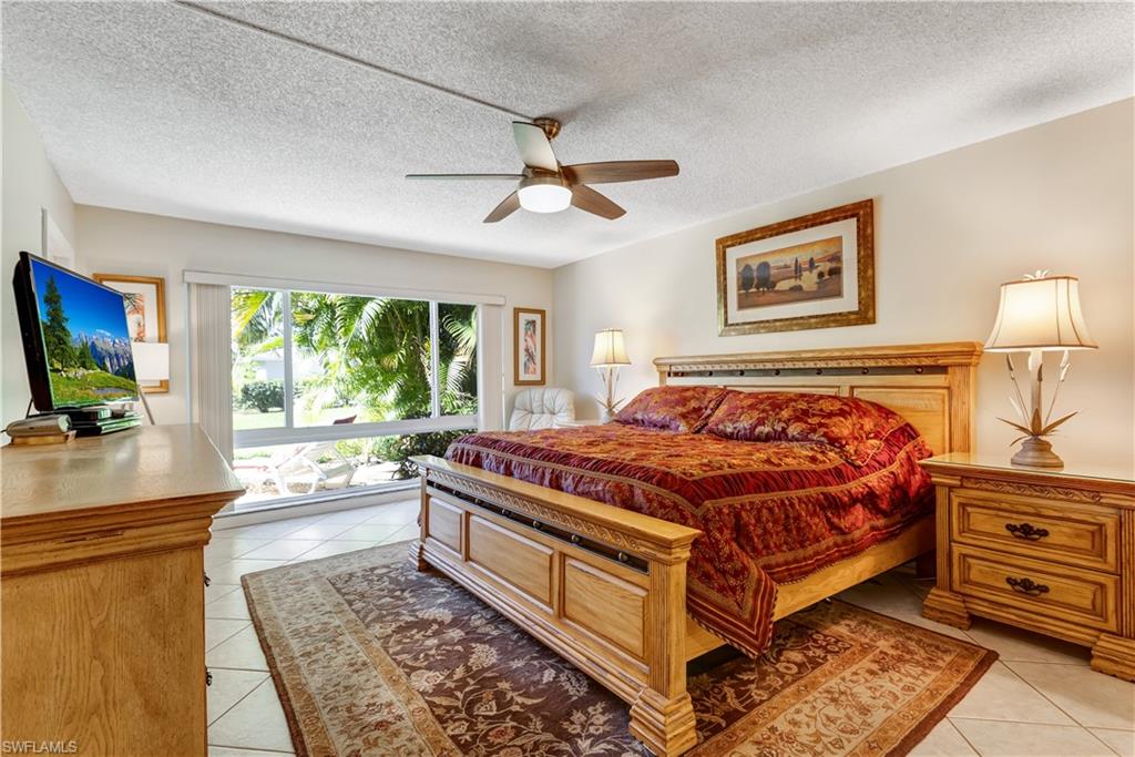 154 Penny Lane, Unit 7 Naples, FL 34112 - Photo 19 of 50 a bed sitting in a bedroom next to a window