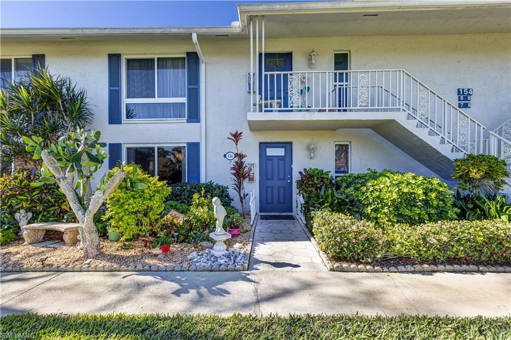 154 Penny Lane, Unit 7 Naples, FL 34112 - Photo 2 of 50 a front view of a house with a yard