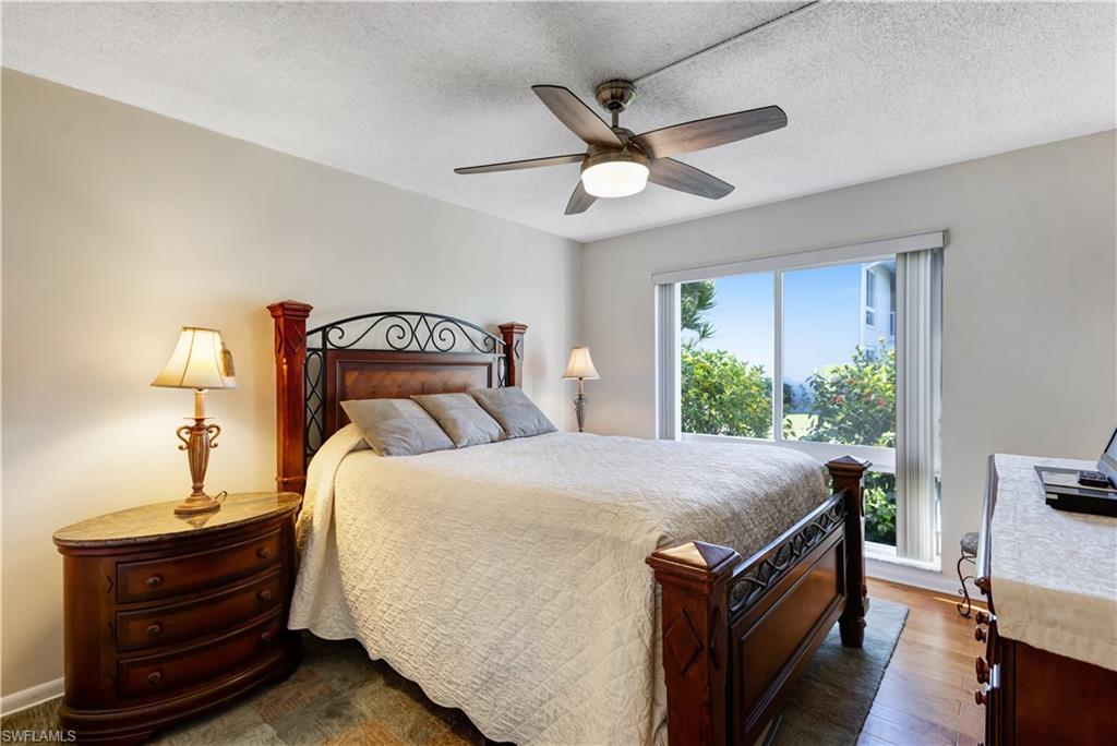 154 Penny Lane, Unit 7 Naples, FL 34112 - Photo 27 of 50 a bedroom with a bed and a chandelier