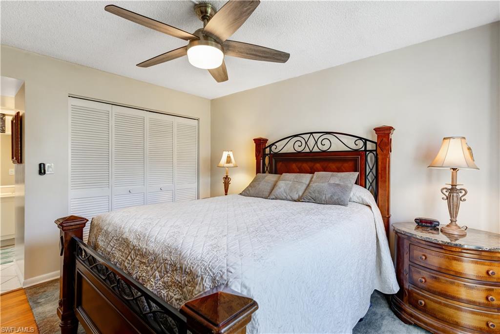 154 Penny Lane, Unit 7 Naples, FL 34112 - Photo 28 of 50 a bedroom with a bed and a chandelier