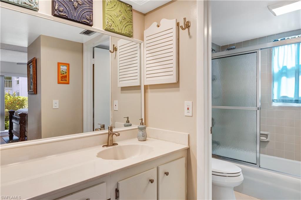 154 Penny Lane, Unit 7 Naples, FL 34112 - Photo 29 of 50 a bathroom with a granite countertop sink toilet and shower
