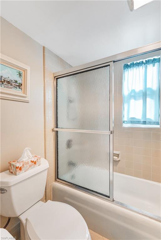 154 Penny Lane, Unit 7 Naples, FL 34112 - Photo 30 of 50 a bathroom with a granite countertop toilet a sink and a bathtub