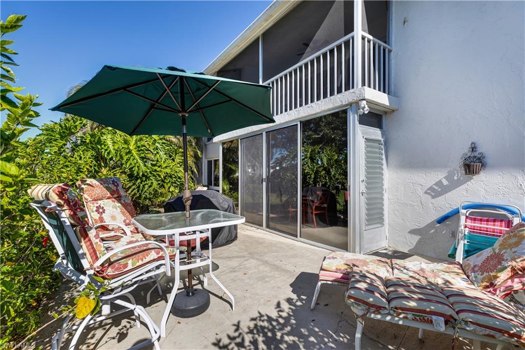 154 Penny Lane, Unit 7 Naples, FL 34112 - Photo 33 of 50 a patio with a table and chairs