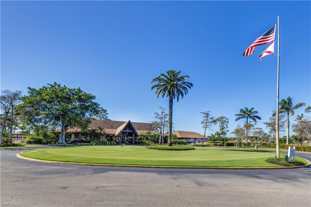 154 Penny Lane, Unit 7 Naples, FL 34112 - Photo 36 of 50 a front view of a house with a yard and potted plants