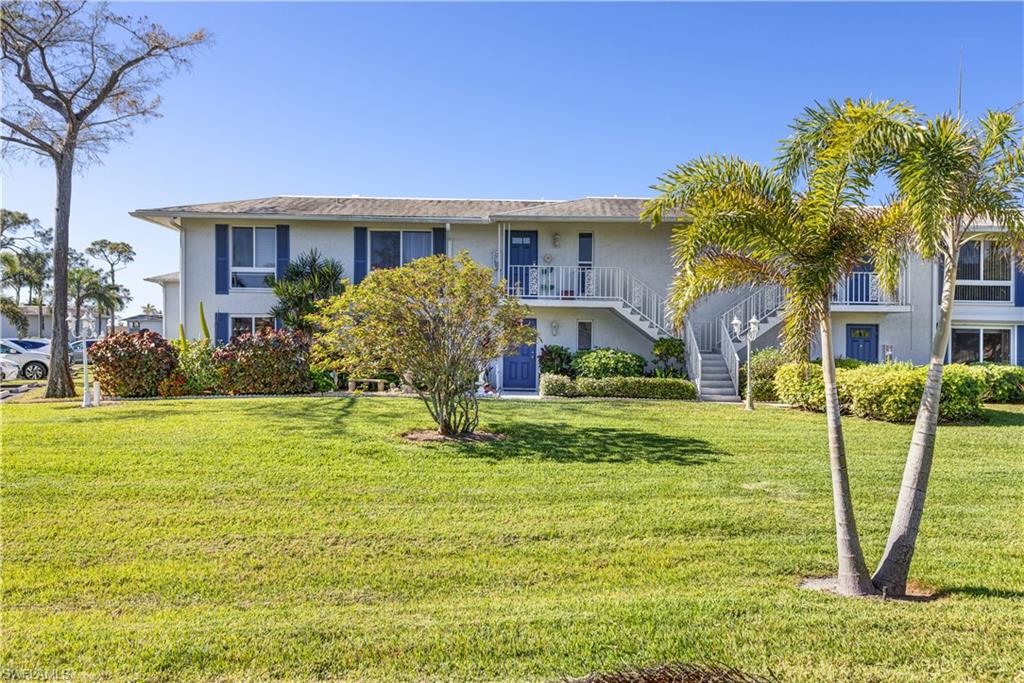 154 Penny Lane, Unit 7 Naples, FL 34112 - Photo 48 of 50 a front view of house and yard with green space