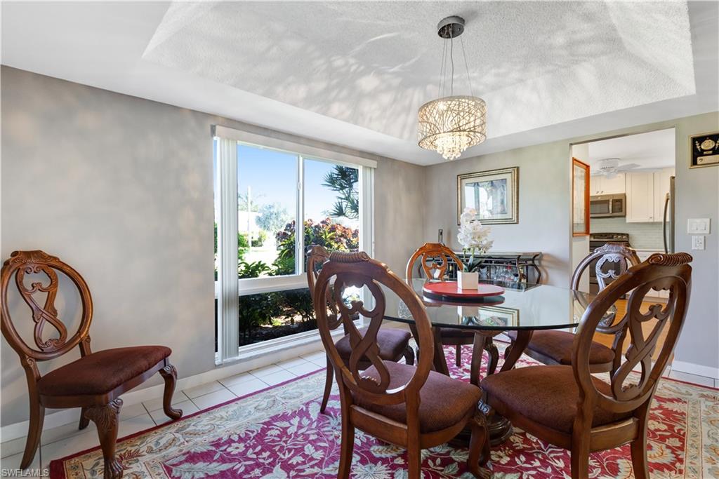 154 Penny Lane, Unit 7 Naples, FL 34112 - Photo 6 of 50 a view of a dining room with furniture and wooden floor