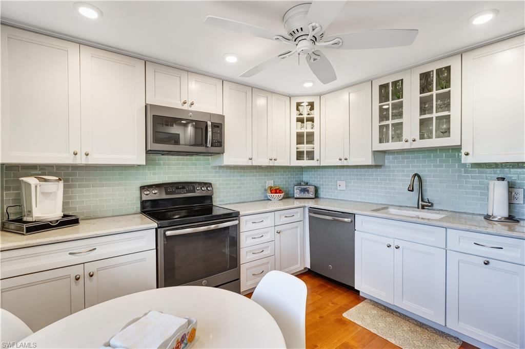 154 Penny Lane, Unit 7 Naples, FL 34112 - Photo 8 of 50 a kitchen with cabinets appliances a sink and a window