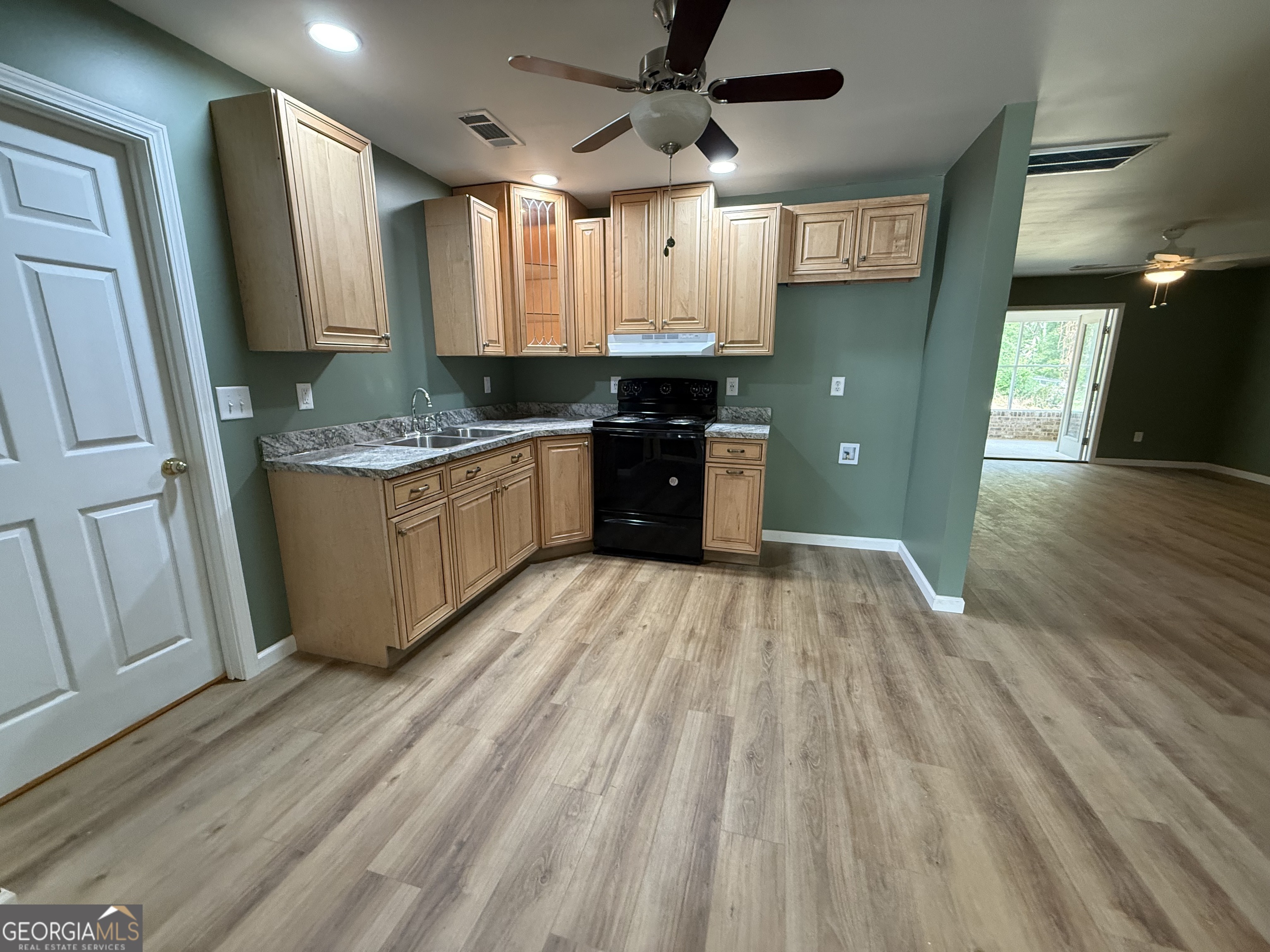 240 Sims Street Barnesville, GA 30204 - Photo 3 of 25 a large kitchen with a sink and wooden floor