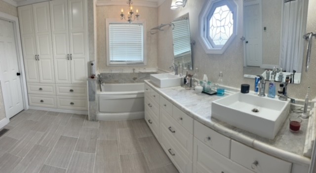 7470 Smith Chapel Road Cookeville, TN 38501 - Photo 19 of 70 a spacious bathroom with double vanity a mirror a bathtub and a shower