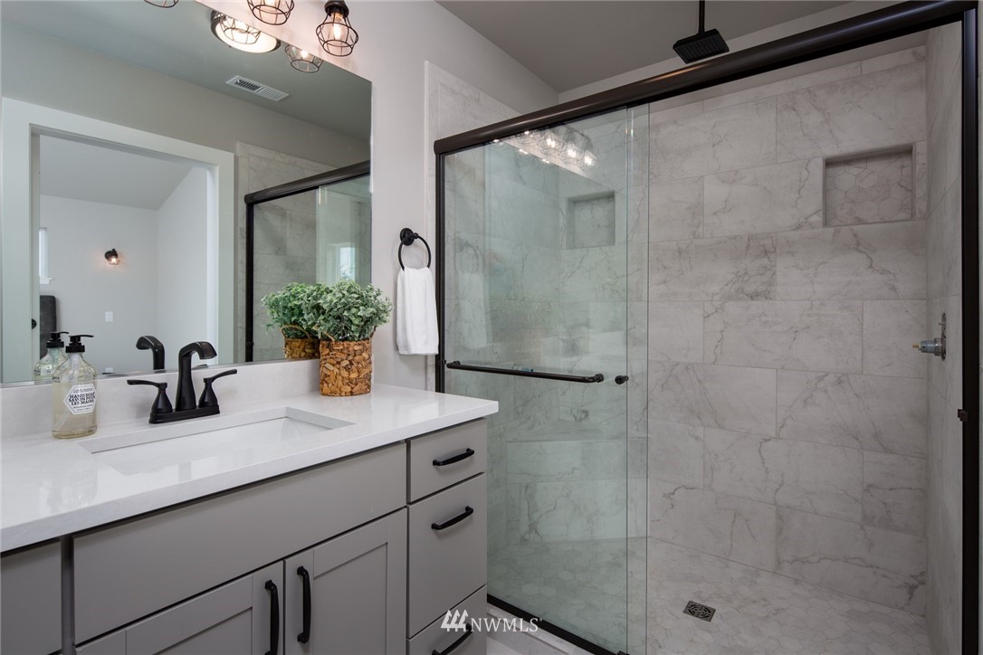 5572 South Church Road Ferndale, WA 98248 - Photo 16 of 30 a bathroom with a granite countertop sink a mirror and shower