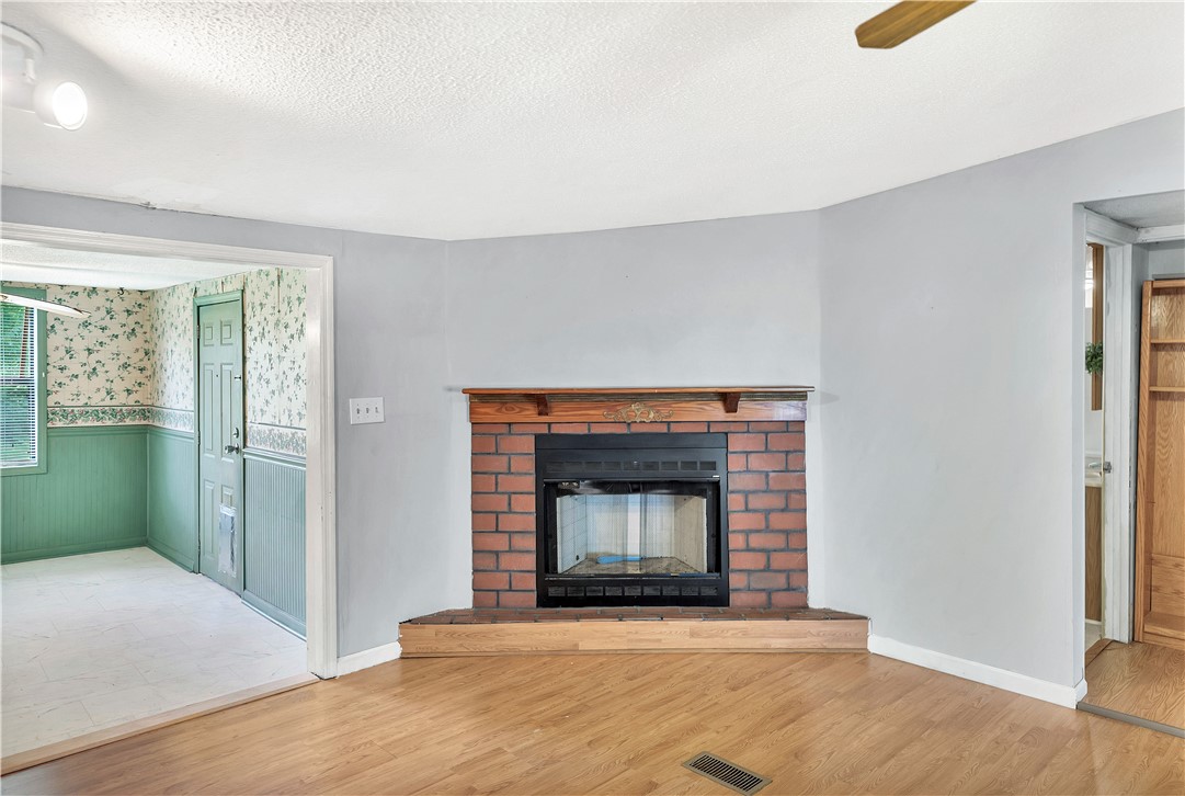 1004 Wiles Road Anderson, SC 29625 - Photo 5 of 26 A corner fireplace with a brick hearth anchors this comfortable living space.