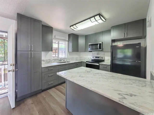a kitchen with a refrigerator and a stove top oven