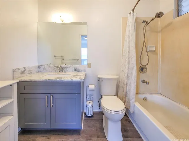 a bathroom with a granite countertop toilet a sink and a bathtub