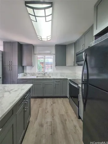 a kitchen with stainless steel appliances granite countertop a sink window and cabinets
