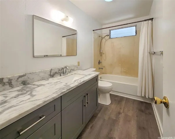 a bathroom with a granite countertop sink toilet and shower