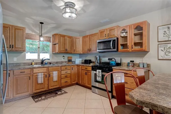 a kitchen with stainless steel appliances granite countertop a sink and a refrigerator