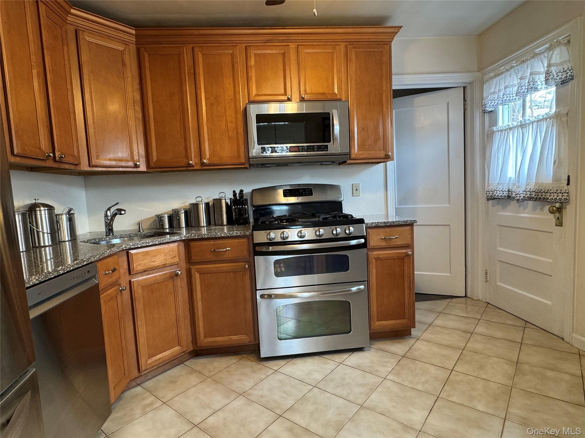 9 Valley Terrace Port Chester, NY 10573 - Photo 21 of 25 a kitchen with granite countertop a stove top oven microwave and cabinets
