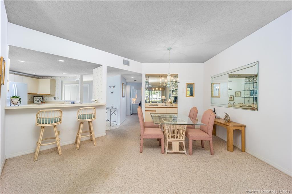 6101 Southeast Landing Way, Unit 5 Stuart, FL 34997 - Photo 5 of 13 a dining room with furniture and a large window