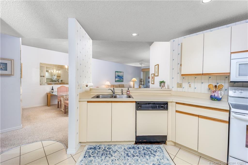 6101 Southeast Landing Way, Unit 5 Stuart, FL 34997 - Photo 7 of 13 a kitchen with stainless steel appliances granite countertop a sink and cabinets