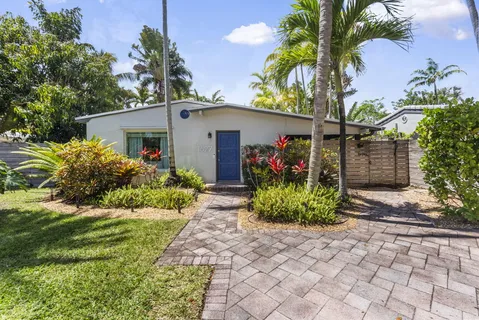 a front view of a house with a yard and potted plants