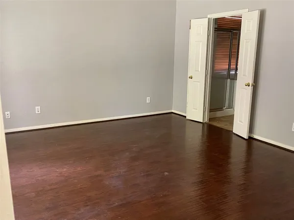 an empty room with wooden floor and closet