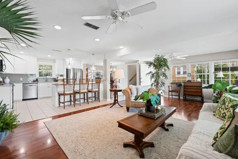 a living room with furniture a chandelier and glass windows