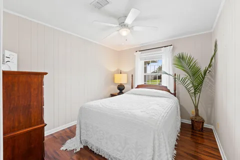 a spacious bedroom with a bed and a potted plant