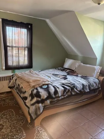 a bedroom with a bed next to a window