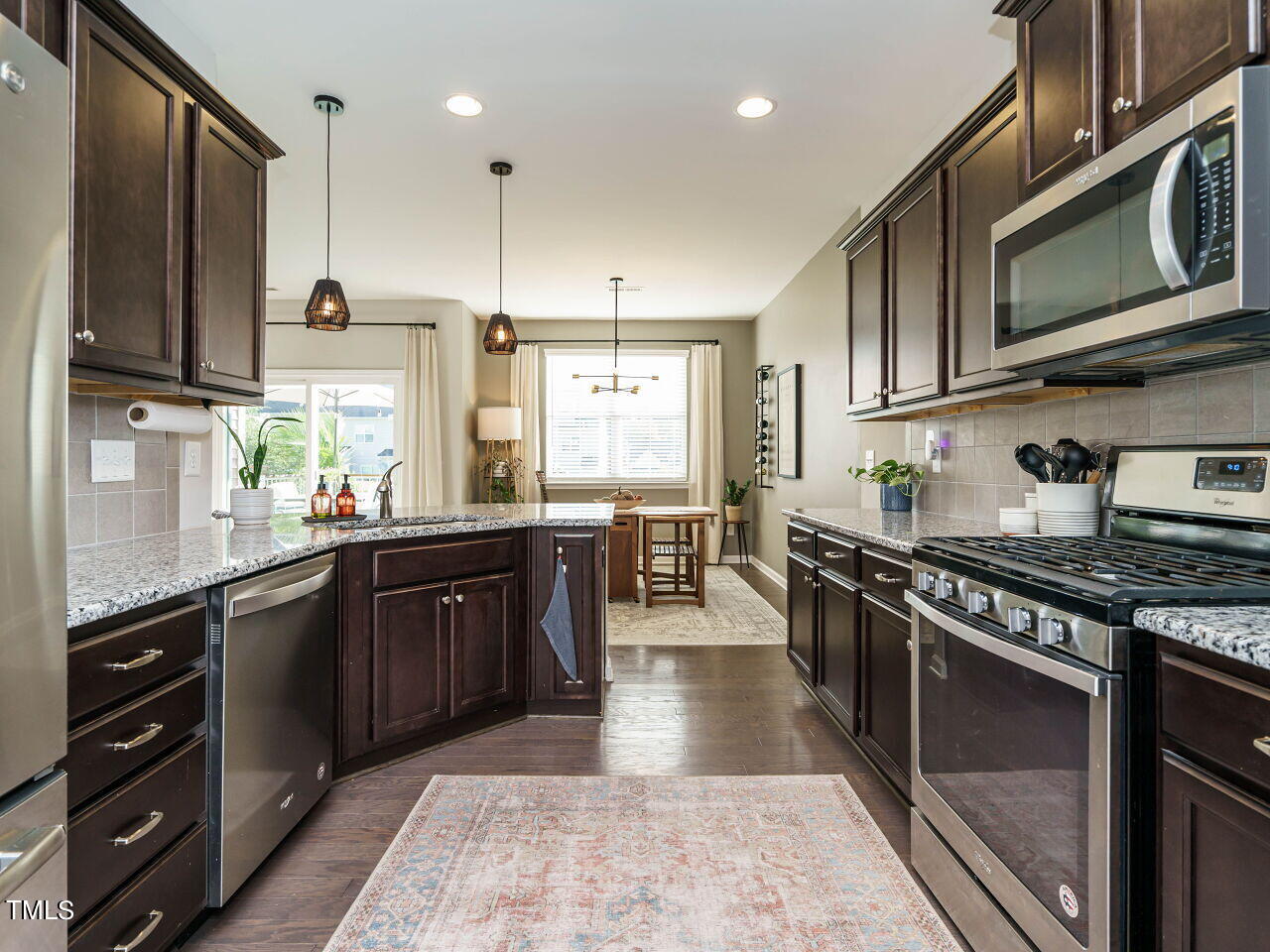 106 Zante Currant Road Durham, NC 27703 - Photo 14 of 27 a kitchen with stainless steel appliances granite countertop wooden cabinets a stove a sink and a microwave