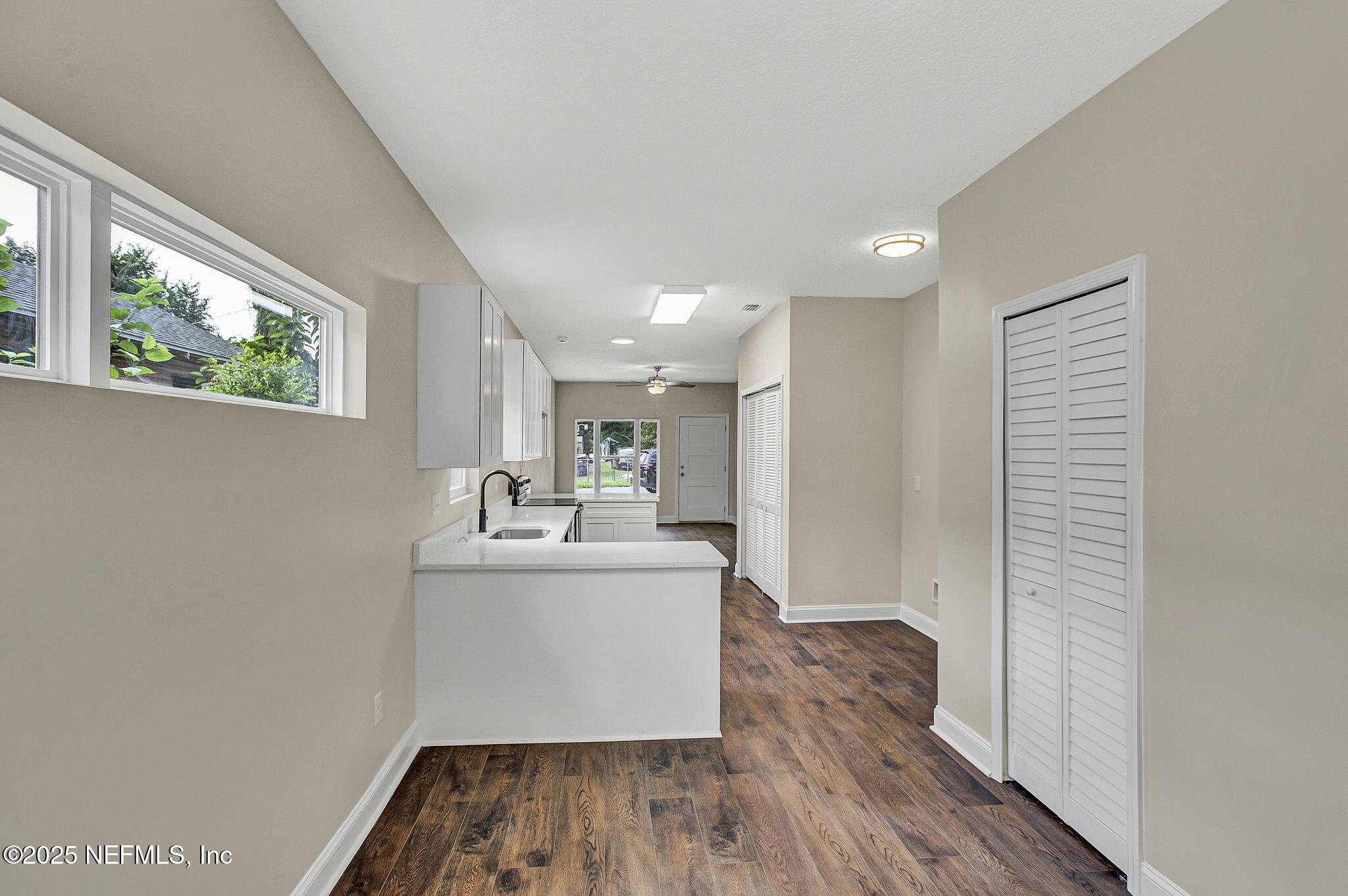 2291 Clemente Drive Jacksonville, FL 32204 - Photo 16 of 20 a room with kitchen island a wooden floor and a window