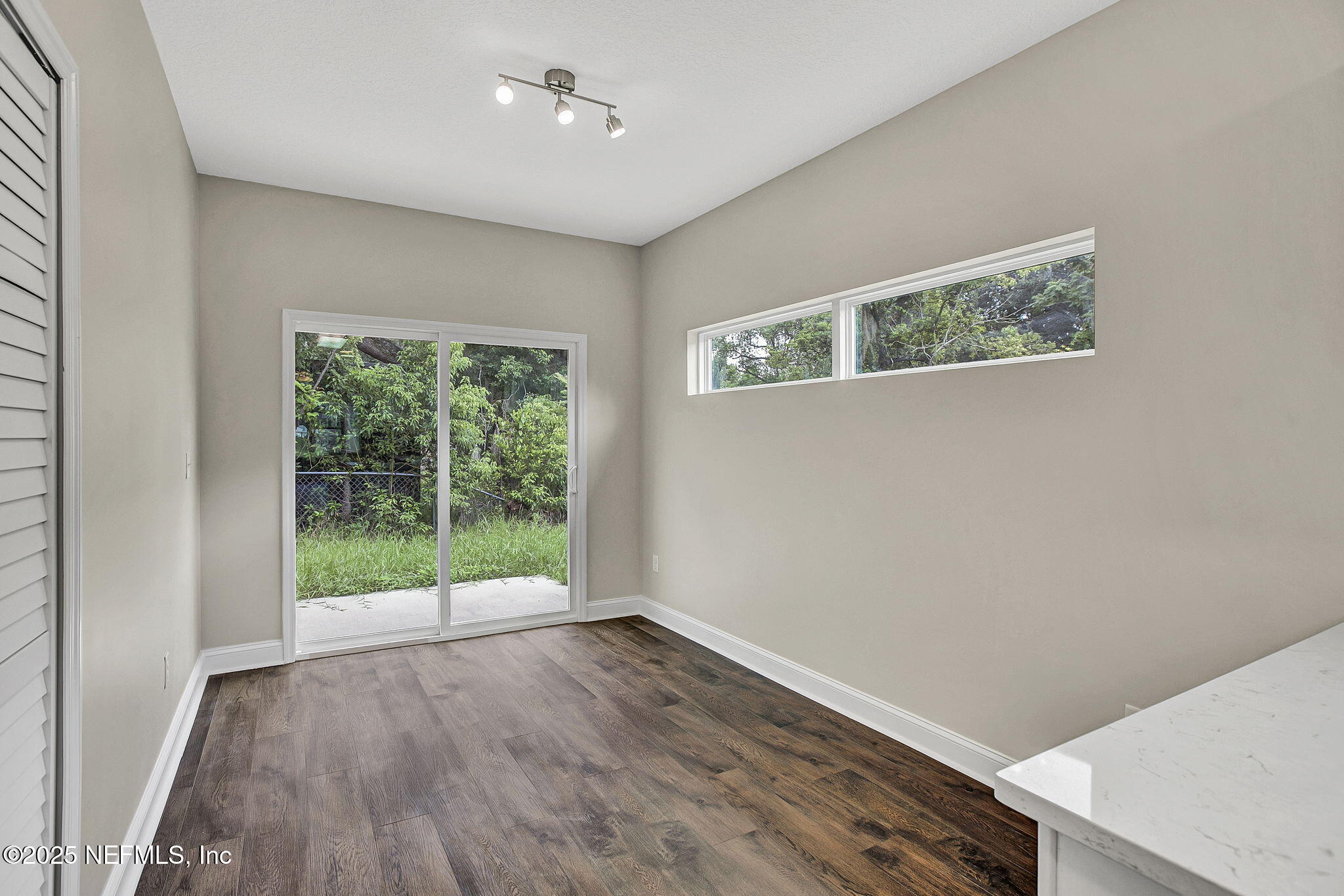 2291 Clemente Drive Jacksonville, FL 32204 - Photo 9 of 20 a view of an empty room with wooden floor and a window