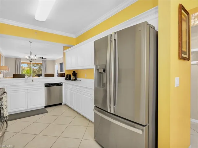 a kitchen with a refrigerator and white cabinets