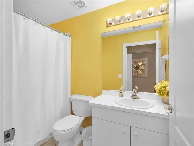 a bathroom with a sink mirror and toilet