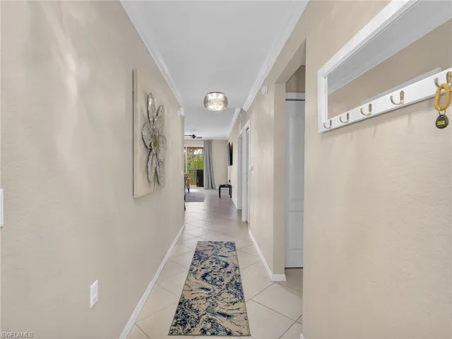 a view of a hallway with wooden floor and a bathroom