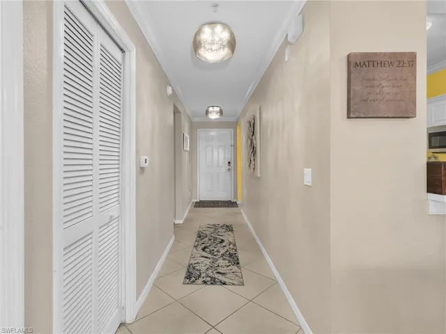 a view of a hallway with wooden floor and a chandelier